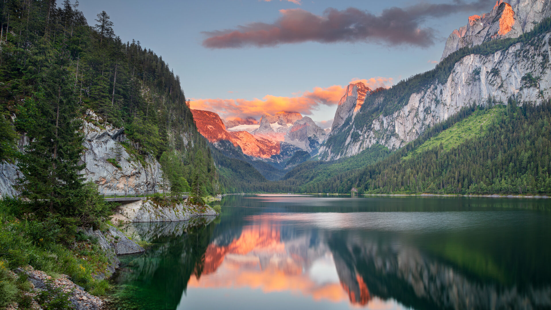 A lake with mountains in the background and clouds above.