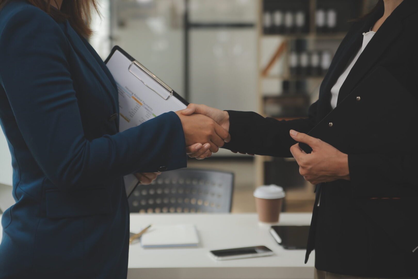 Two people shaking hands in a room.